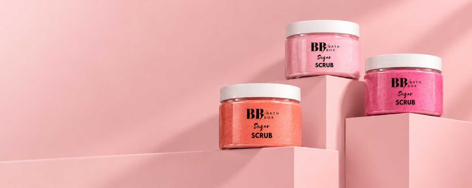 Pembe podyumlarda duran üç Bath Box sugar scrub kavanozu
