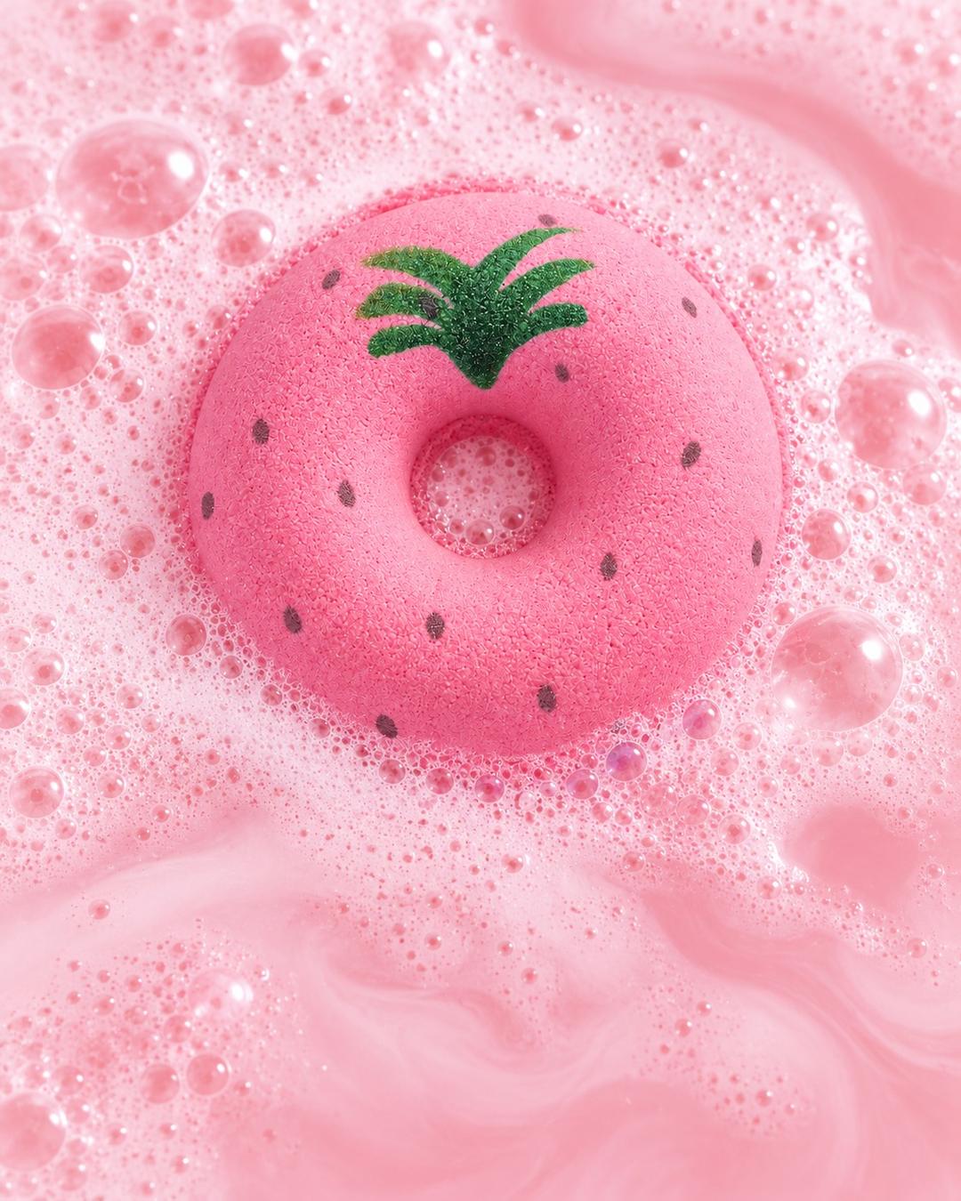 Çilek desenli pembe donut banyo topu, köpüren pembe suyun içinde